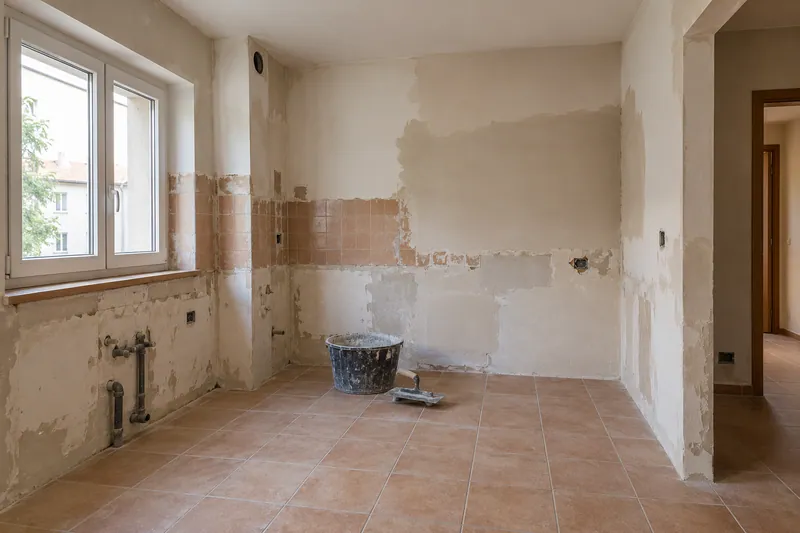 Visualización conceptual IA: Cocina sin muebles con paredes en preparación y zonas de enlucido.